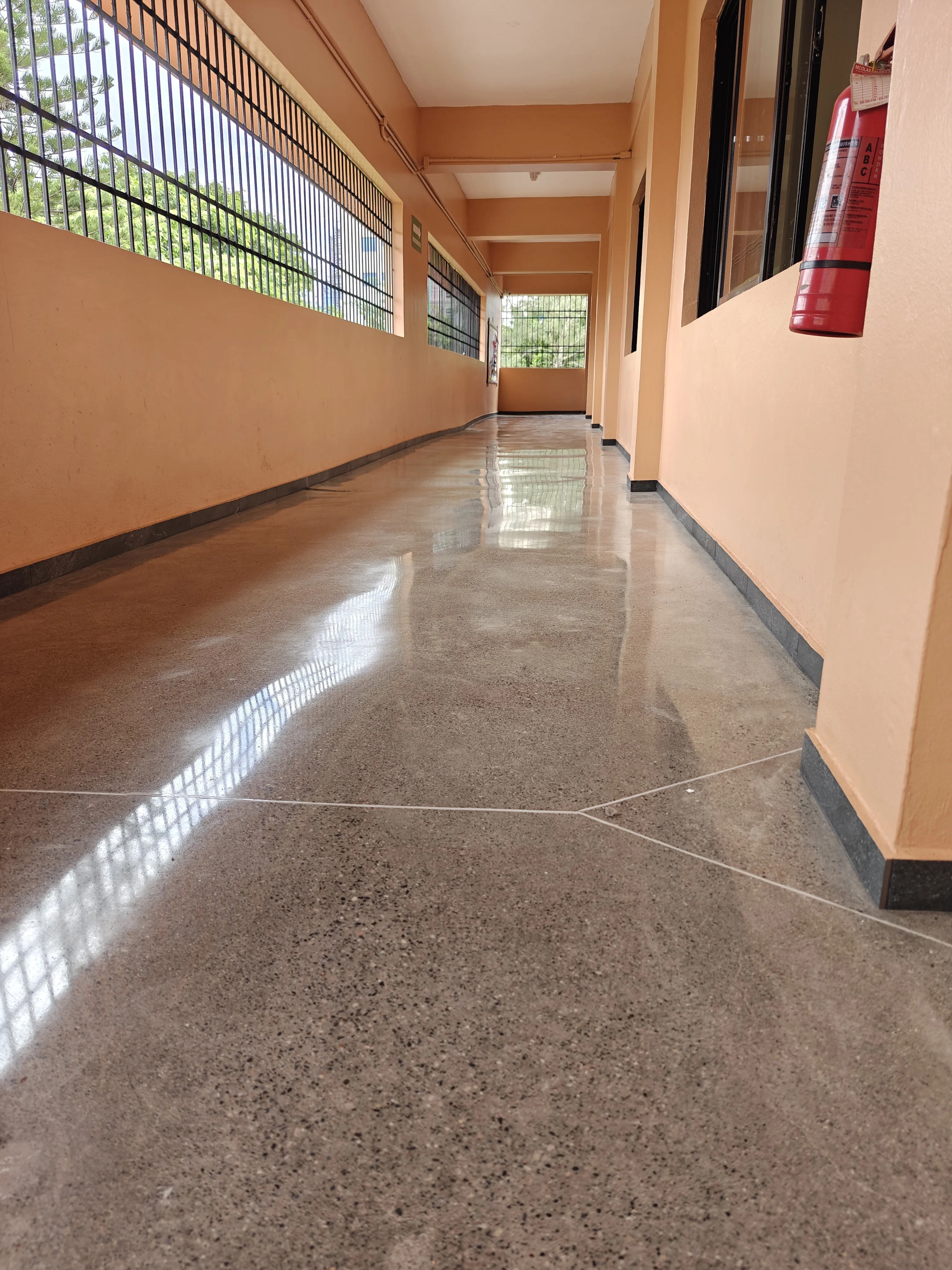 BrightConcrete™ — Pasillo de circulación con piso de concreto pulido de alto brillo, resistente al tránsito constante.