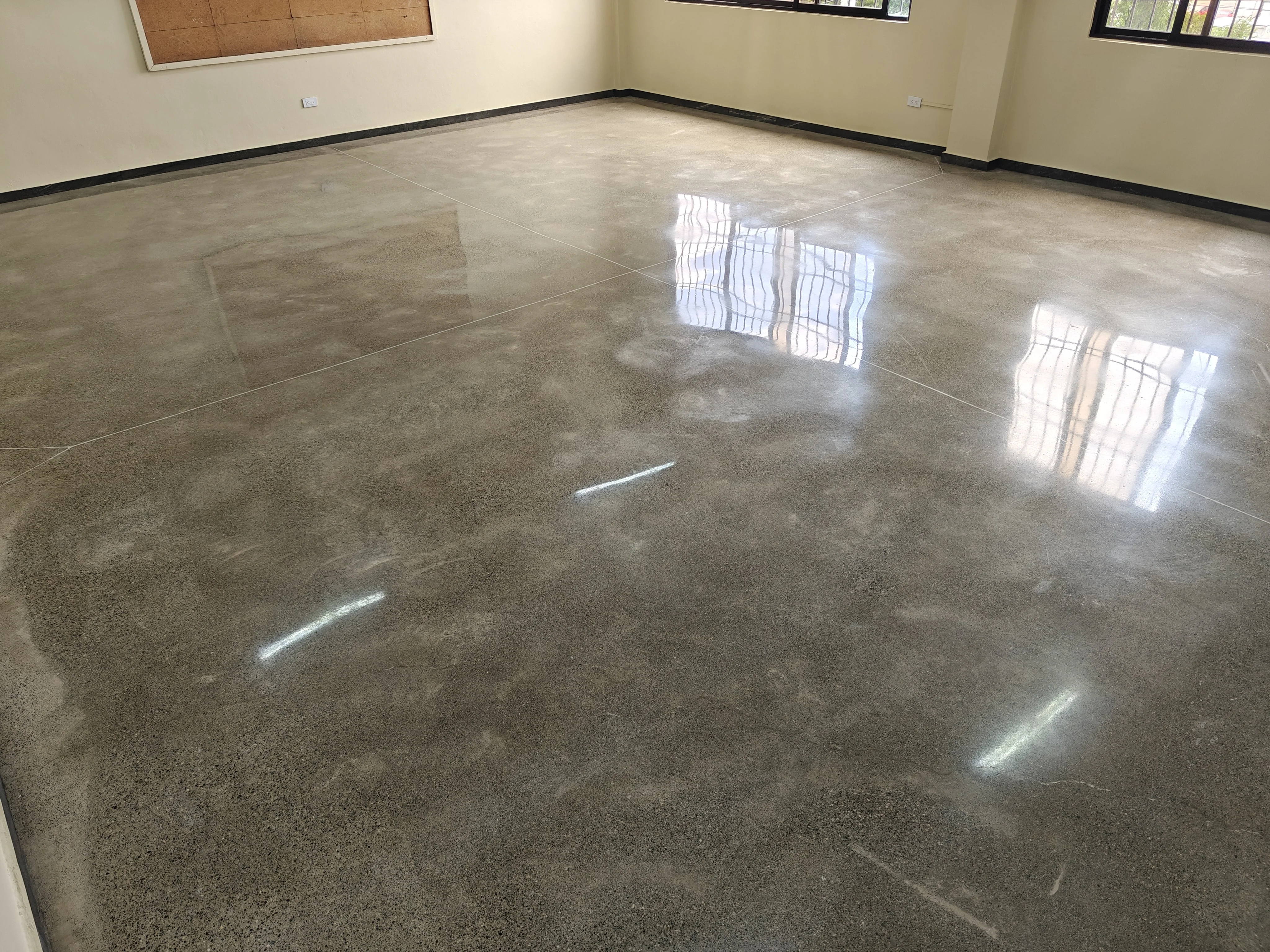 BrightConcrete™ — Salón terminado en concreto pulido monolítico, sin más divisiones que los cortes de control, ideal para grandes superficies.